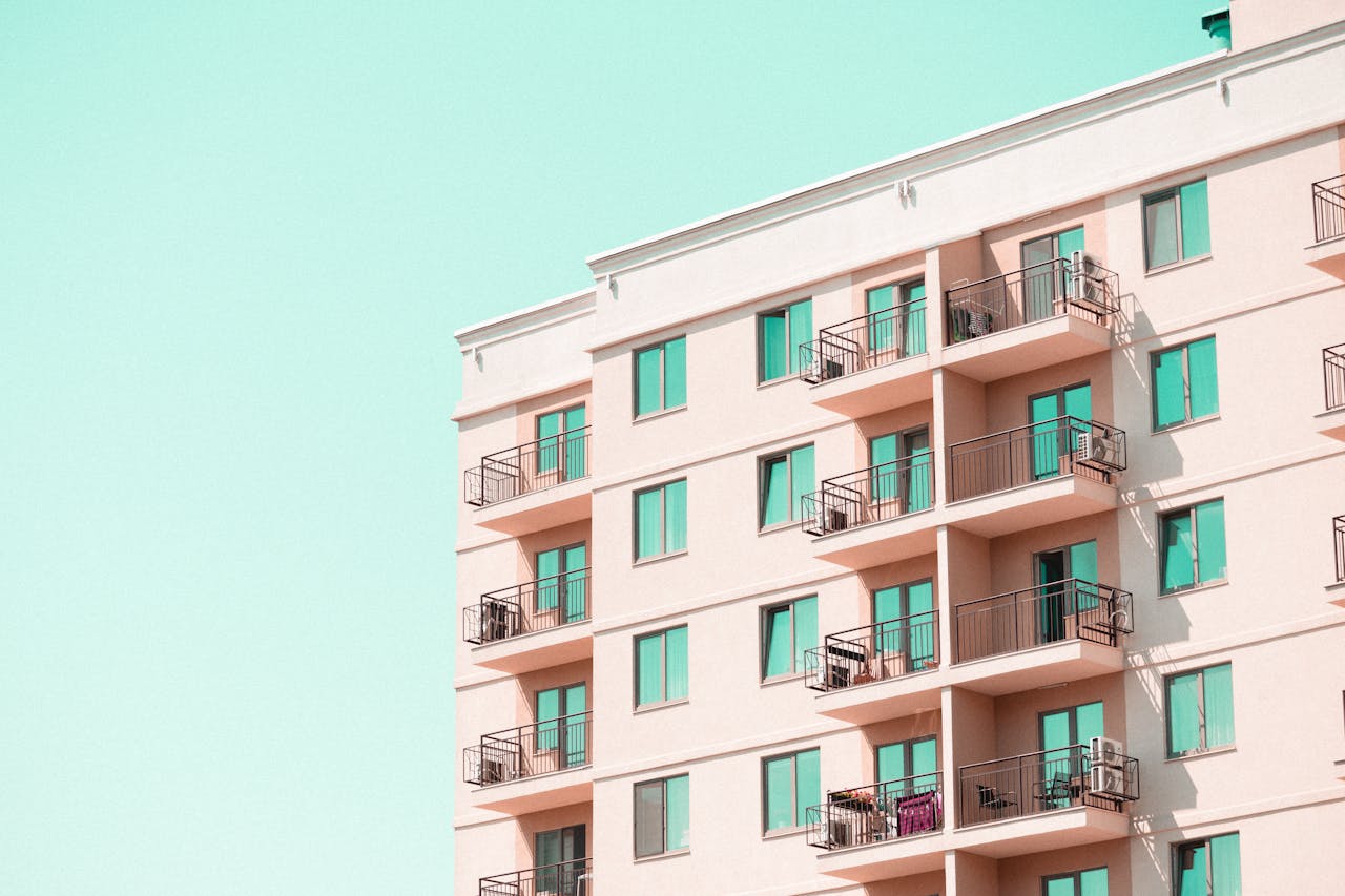 about-02 Modern apartment building facade with balconies under a clear blue sky.
