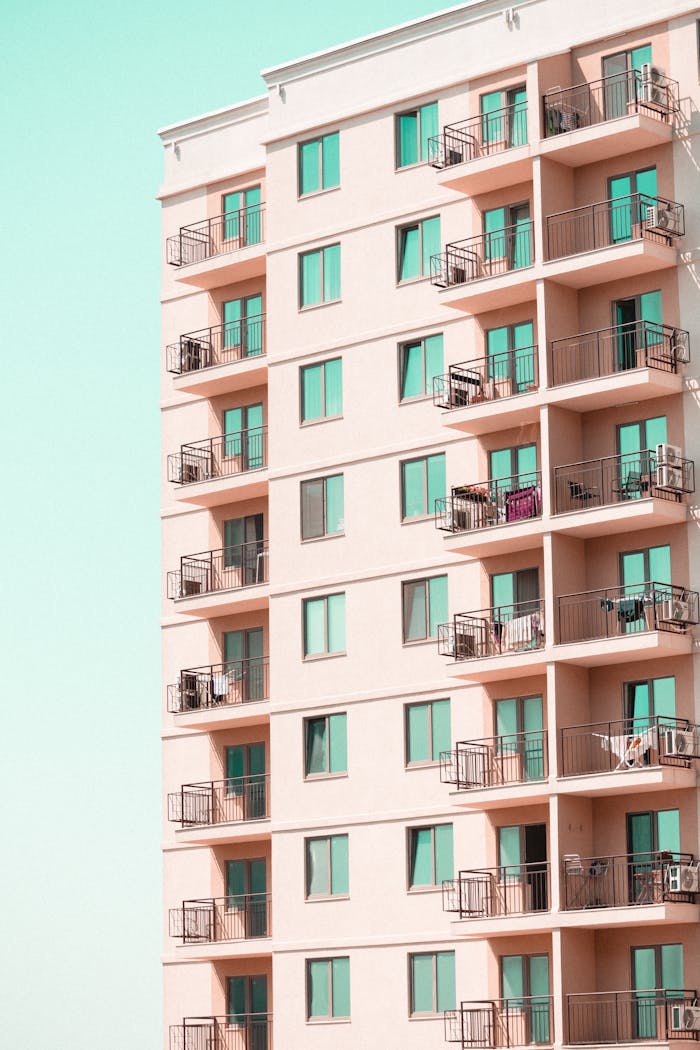 services-03 Contemporary apartment building facade with multiple balconies under a clear sky.